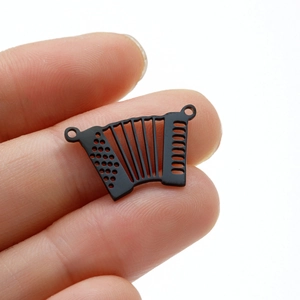 Detailed macro view of a matte black accordion musical instrument pendant for DIY jewelry