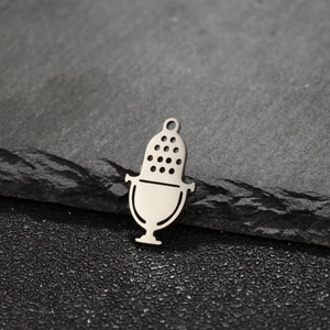Macro detail of a polished stainless steel microphone pendant on a slate background
