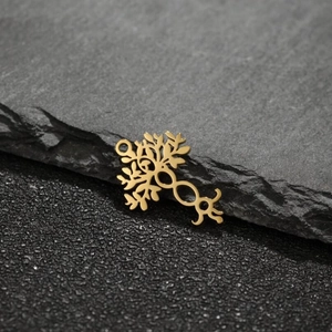 Macro detail of golden tree of life and infinity symbol pendant on a stone background