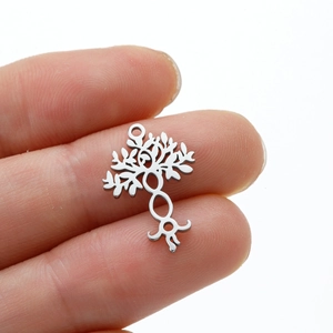 Polished stainless steel Tree of Life pendant held by hand showing detailed leaf design