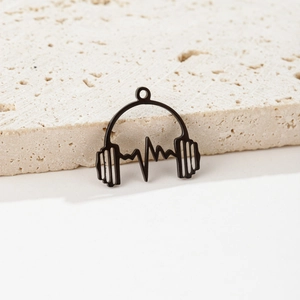 Close-up of black stainless steel headphone heartwave pendant on travertine stone