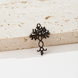 Close-up of matte black tree of life pendant on elegant beige stone travertine base