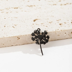 Macro detail of dandelion floral pendant with matte finish resting on travertine stone