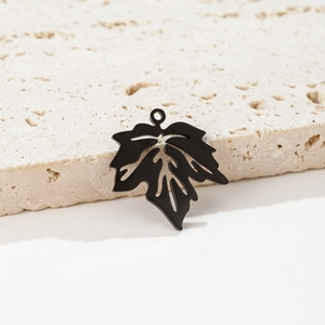 Détail macro du pendentif feuille d'érable noire avec texture de veines et fini mat