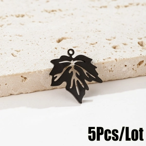 Détail macro de 5 pendentifs feuilles d'érable en acier noir mat pour bijoux