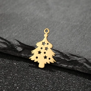 Macro shot of a hollow gold Christmas tree pendant on a dark stone textured background