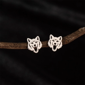 Retro stainless steel wolf head stud earrings displayed on a rustic wooden branch