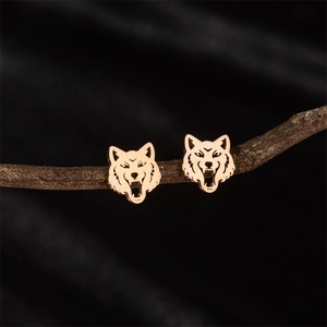 Vintage wolf head stud earrings in hollowed gold stainless steel on rustic branch