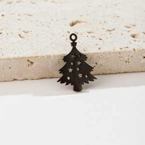 Close-up of black cutout Christmas tree charms with star motifs on marble display