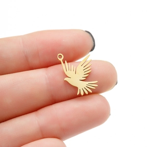 Dettaglio di un piccolo ciondolo a forma di uccello placcato oro 18k per gioielli