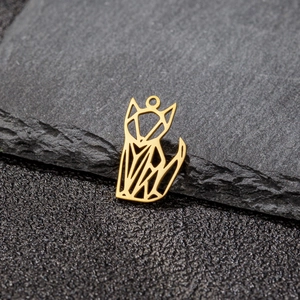 Close-up of geometric origami fox pendant in gold stainless steel on stone