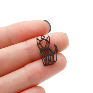 Close-up of a mini stainless steel origami fox pendant held between fingertips