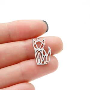 Macro detail of silver geometric origami fox pendant held to show small scale and size
