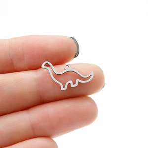 Macro view of mini hollow dinosaur pendant held by fingers to show small size