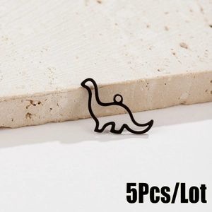 Detail view of 5pcs black cutout stainless steel dinosaur charms on white stone base