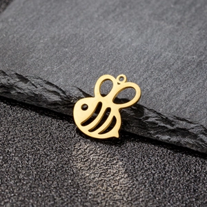 Detailed macro view of a golden hollow bee pendant for handmade jewelry making