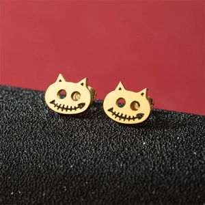 Golden Halloween cat stud earrings with cutout details on a modern red and black background