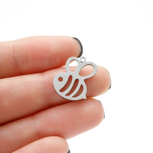 Close-up of a hollow honey bee pendant in polished metal for DIY jewelry making