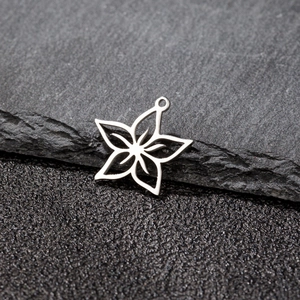 Macro detail of star-shaped hollow flower pendant in stainless steel for DIY jewelry