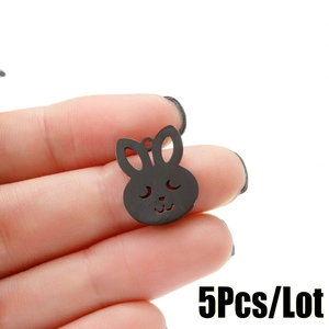 Macro view of five matte black rabbit head metal pendants with hollow detail