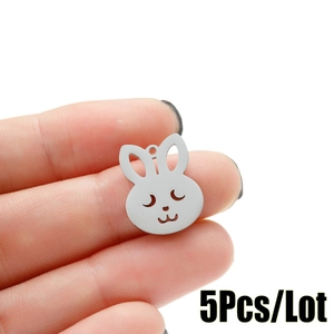 Detail of hollow rabbit stainless steel charm pendant held by hand for scale