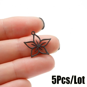 Close-up of five-petal hollow star flower pendant in matte black finish on fingers