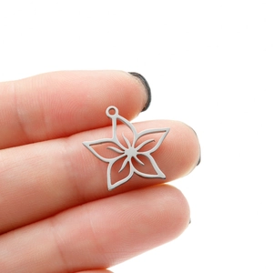 Detail view of a hollow star pendant in silver stainless steel held for size scale