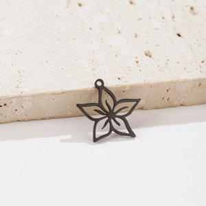 Detail shot of a matte black hollow flower pendant on natural beige stone texture