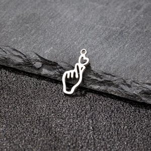 Macro shot of silver heart gesture pendant on stone, detail of stainless steel charm