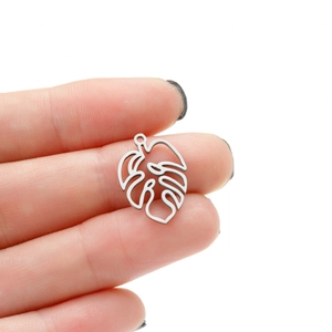 Detailed close-up of a silver stainless steel monstera leaf pendant held to show size