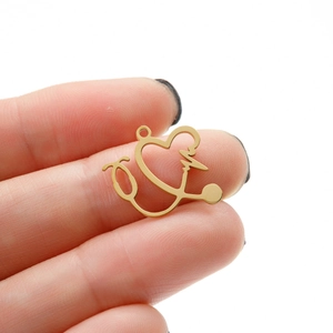 Close-up of golden stethoscope heart pendant showing polished finish and medical design