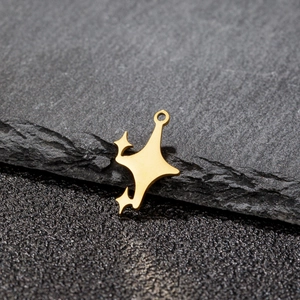 Pendentif étoile en acier inoxydable doré poli sur une roche texturée sombre