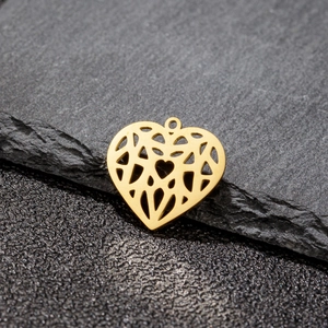 Detailed view of heart-shaped hollow metal pendant with geometric cutouts in gold finish