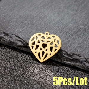Golden hollow heart pendant with geometric origami patterns on a textured stone surface