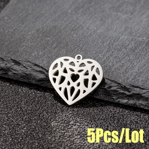 Macro detail of geometric hollow heart pendant on stone, DIY jewelry accessory
