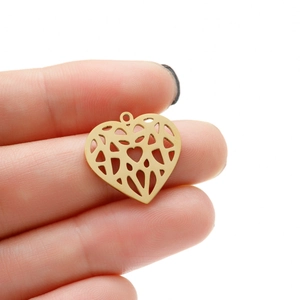 Macro shot of a golden hollow heart pendant with geometric origami patterns for DIY jewelry
