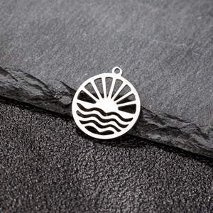 Close-up of a silver hollow wave sun pendant showing intricate laser-cut details