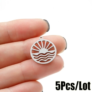 Detailed view of five silver-toned wave and sun charms for DIY jewelry making