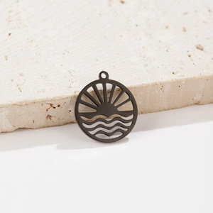 Close-up of black wave and sun hollow pendant on a natural stone background