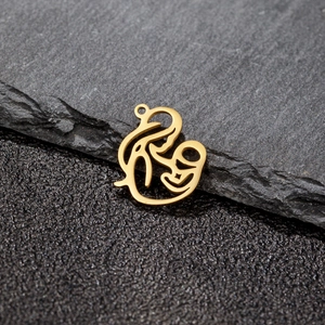 Détail d'un pendentif mère-enfant doré sur fond de pierre avec une finition brillante