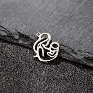 Détail macro du pendentif évidé mère et enfant en acier poli de couleur argentée