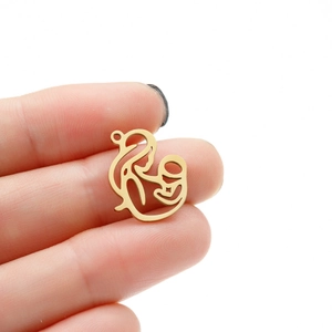 Détail d'un pendentif mère et bébé doré tenu à la main pour référence de taille réelle