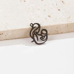 Vue macro d'un pendentif mère et enfant en acier inoxydable noir sur surface en pierre