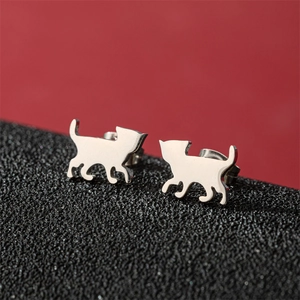 Macro shot of silver cat earrings with polished finish on a red and black background