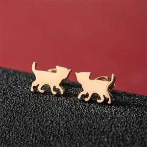 Macro detail of polished rose gold cat-shaped stud earrings on a sleek dark surface