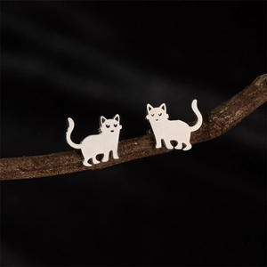 Boucles d'oreilles chat minimalistes en acier inoxydable argenté sur une branche de bois