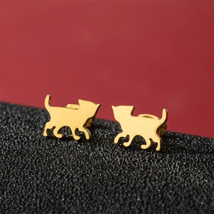 Detailed view of golden stainless steel cat-shaped earrings on a dark textured base