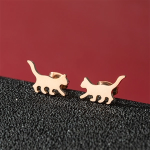 Asymmetric walking cat stud earrings in gold finish for women on elegant red background