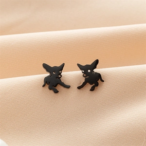 Détail macro de boucles d'oreilles Chihuahua noir mat sur fond de tissu doux
