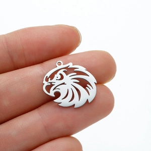 Detail of silver eagle pendant held in hand to show the actual size and hollow design